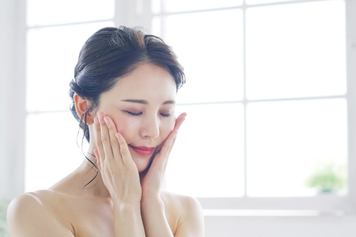 chiết xuất cúc la mã có tác dụng gì làm dịu làn da nhạy cảm cô gái áp hai bàn tay lên mặt nhắm mắt