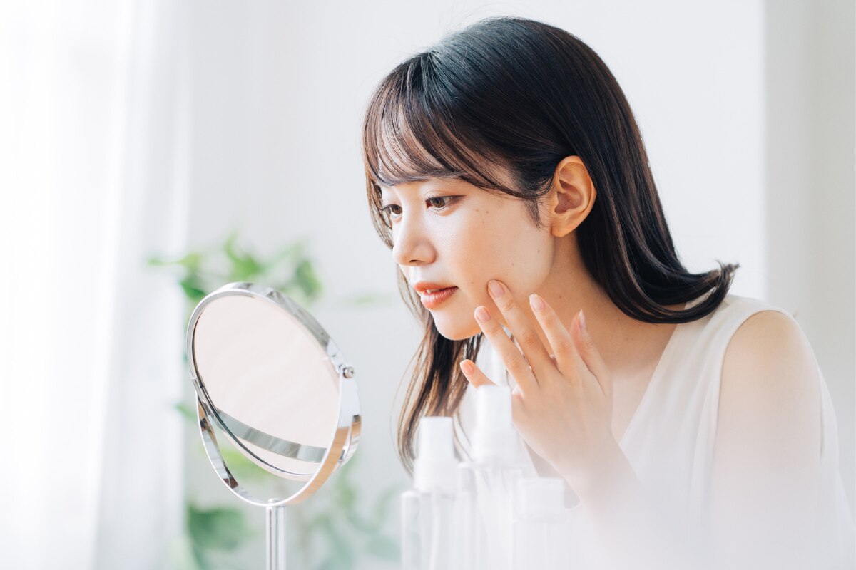 chiết xuất cúc la mã có tác dụng gì giảm viêm cô gái soi gương lấy hai ngón tay chạm nhẹ vào má