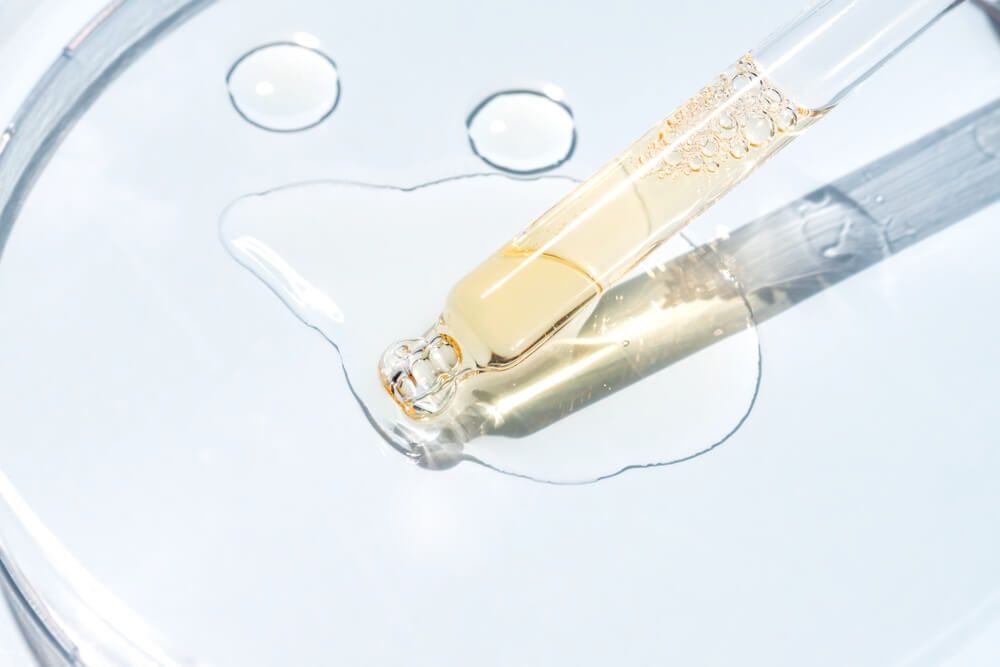 dược mỹ phẩm khi nào nên dùng dược mỹ phẩm ống nhỏ serum màu vàng đặt trên một tấm kính tròn bằng thuỷ tinh