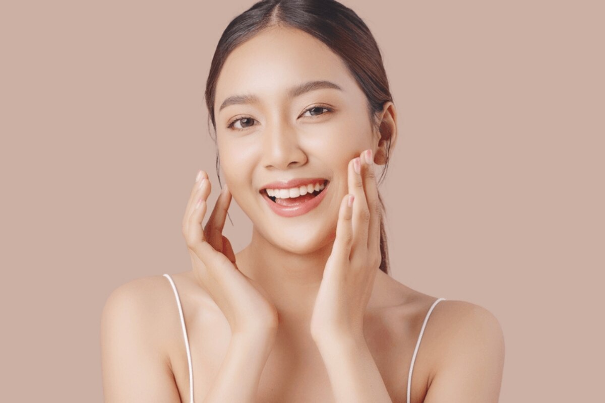 serum là gì serum có tác dụng gì chống oxy hóa cho da cô gái cười tươi hai tay chạm nhẹ vào má