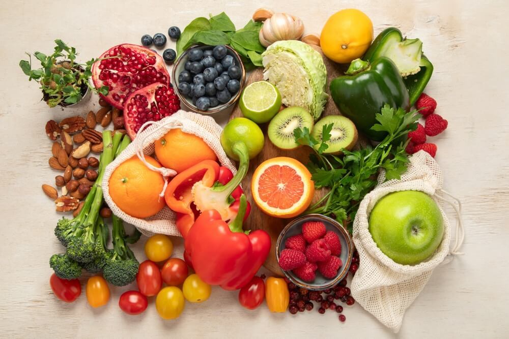 cách khắc phục da bị chảy xệ thực phẩm chứa vitamin c ớt chuông việt quất cam lựu đỏ chanh cà chua bi dâu tây hạt hạnh nhân trên bàn gỗ trắng