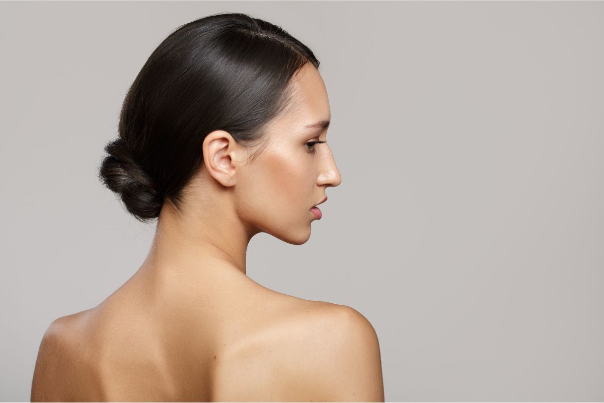 cách búi tóc đẹp cho tóc ngắn cô gái lưng trần quay lưng nhìn nghiêng tóc đen búi thấp