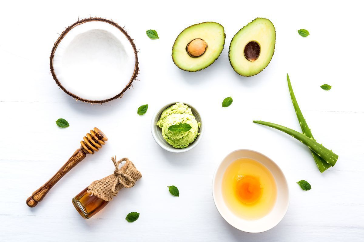 nên ủ tóc trước hay sau khi gội đầu các nguyên liệu tự nhiên như nha đam, mật ong, bơ đặt trên bàn