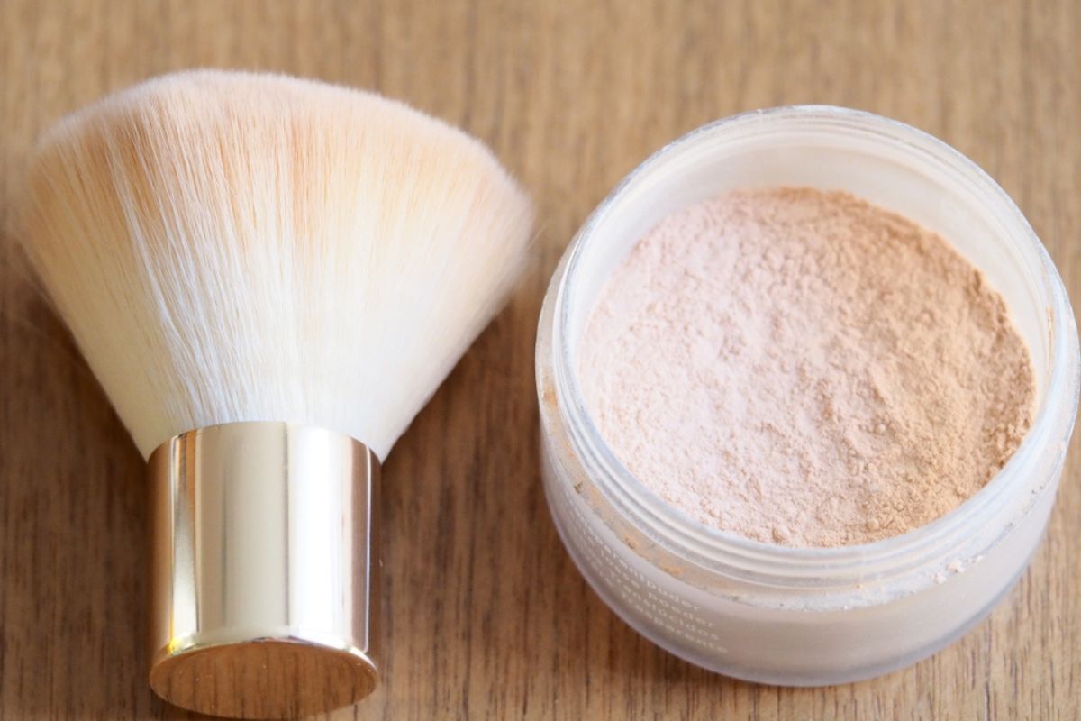 cách bôi lại kem chống nắng phấn chống nắng cọ kế bên hộp phấn phủ trên bàn gỗ