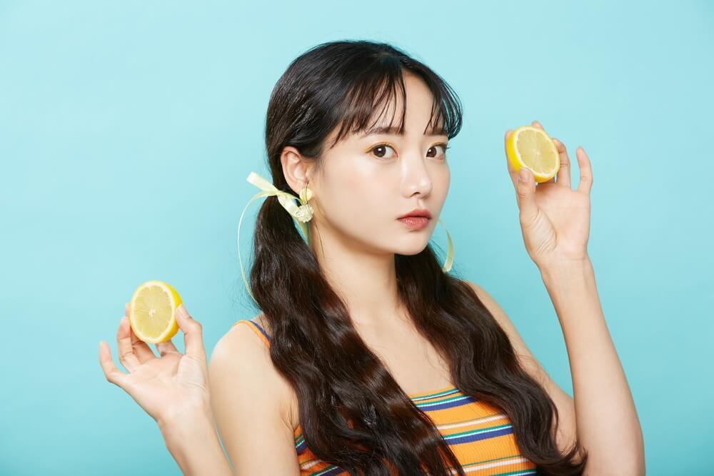 gội đầu bằng chanh gội đầu bằng chanh có tác dụng gì cô gái buộc tóc hai bên đang cầm nửa quả chanh