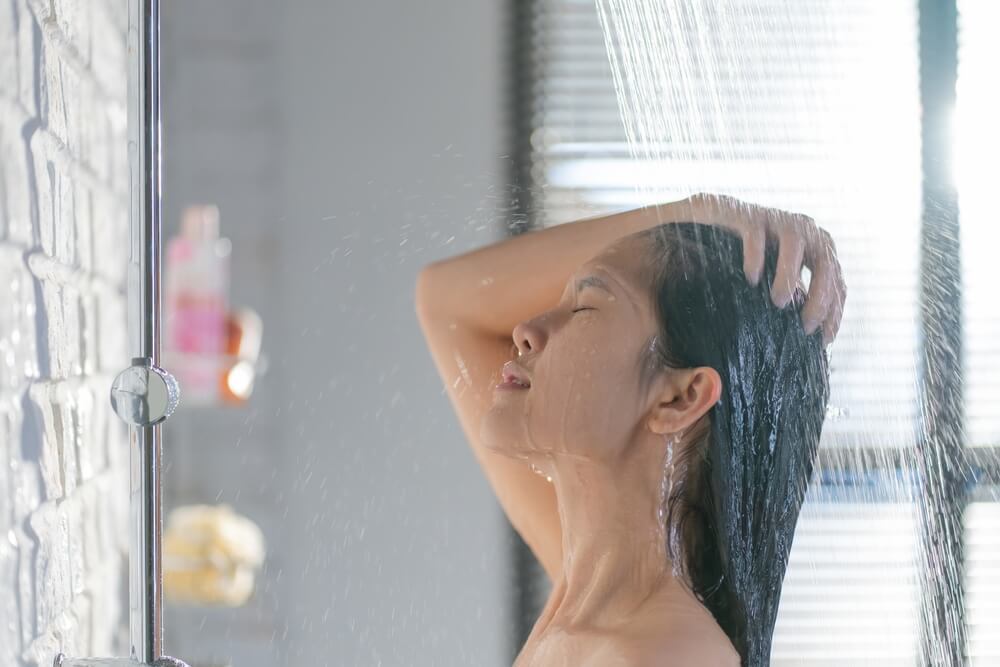 gội đầu bằng chanh gội đầu bằng chanh có giúp tóc nhanh dài hơn không cô gái đang nhắm mắt và tắm gội dưới vòi hoa sen