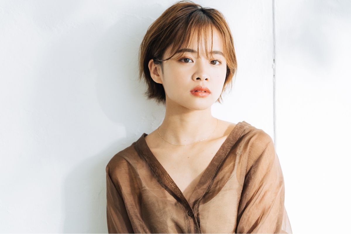 Tóc layer nữ cô nàng tóc ngắn mái thưa mặc áo sơ mi nâu 