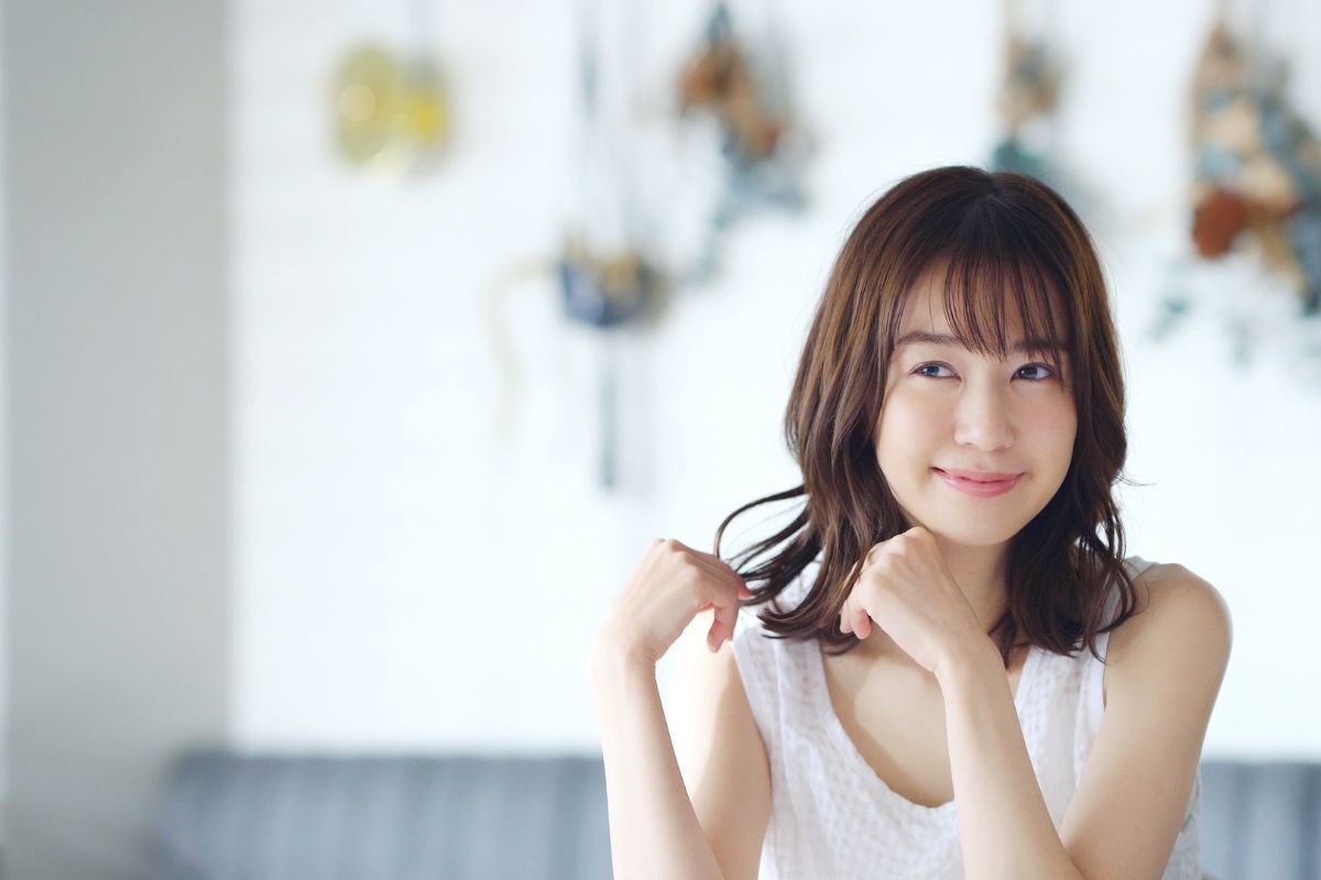 Mái bay Hàn Quốc cô gái tóc ngang vai mặc áo ba lỗ màu trắng đang mỉm cười ảnh chụp trong phòng