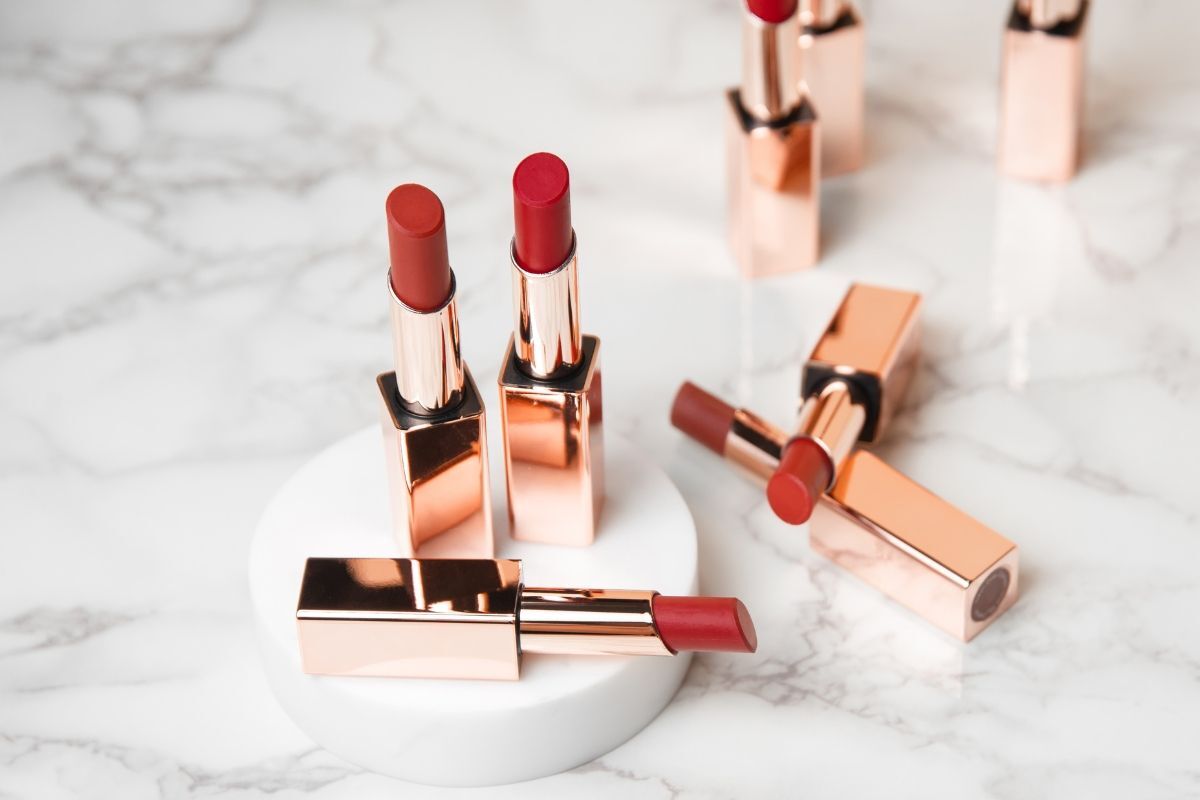 Son màu đỏ cam nhiều thỏi son đỏ cam bị mở nắp và đặt trên bàn vân đá