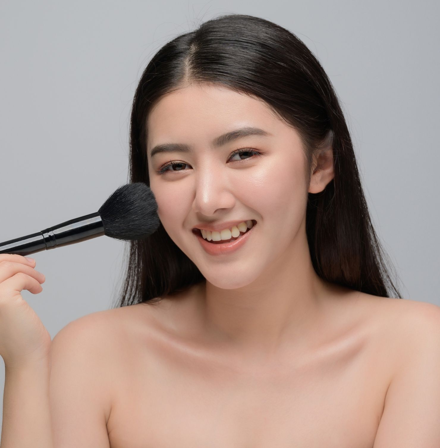 cách xác định hình dạng khuôn mặt cô gái cầm cọ trang điểm lên mặt 