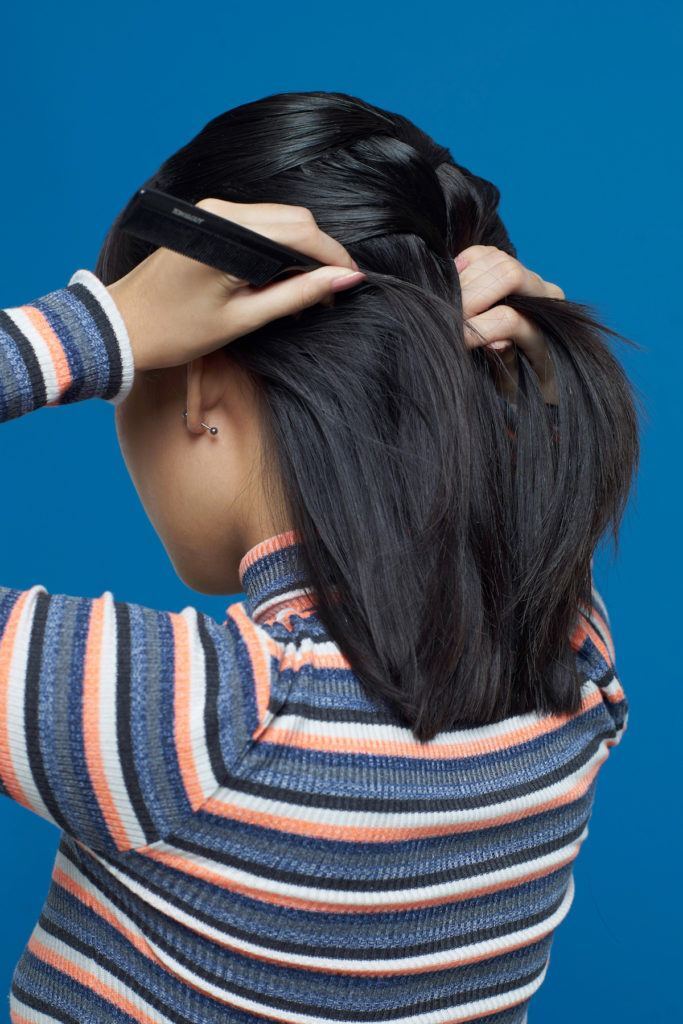 Wanita asia berambut pendek mengepang rambut dengan sisir sasak