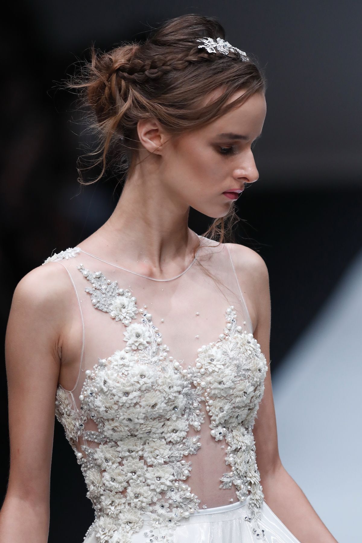 Padukan gaya messy bun dengan kepang klasik sebagai ‘bando’. (Foto: Jakarta Fashion Week 2018)