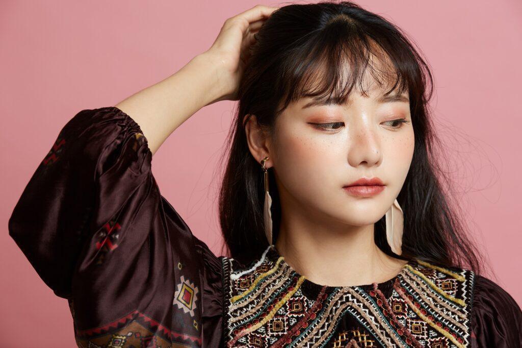 Wanita Asia rambut panjang sedang memegang salah satu sisi rambut.