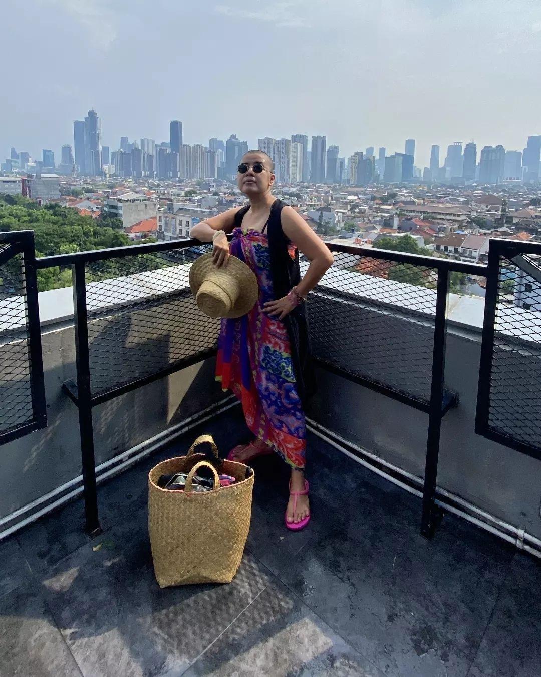 Terry Endropoetro berpose berdiri mengenakan kain tenun dan vest.