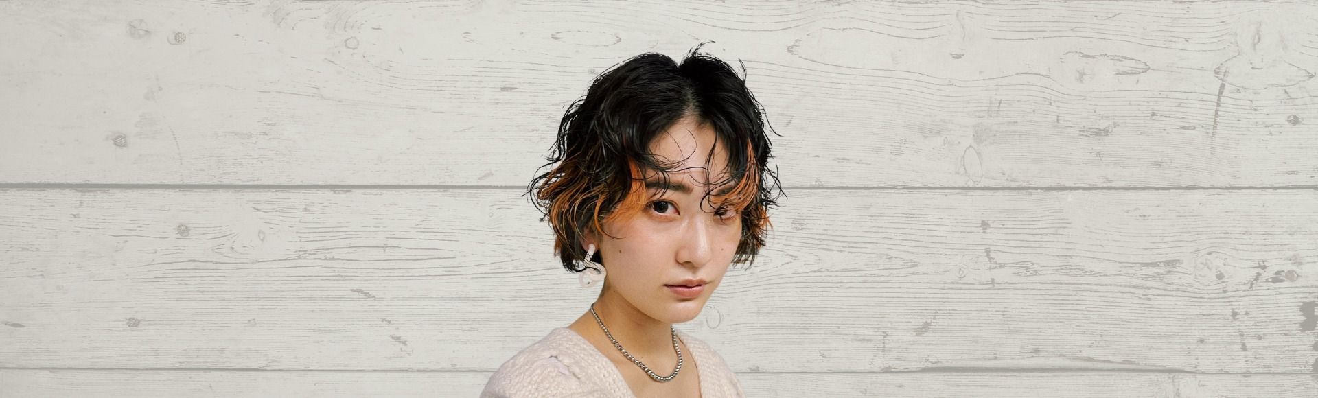 Wanita Asia dengan rambut pendek highlight warna orange.