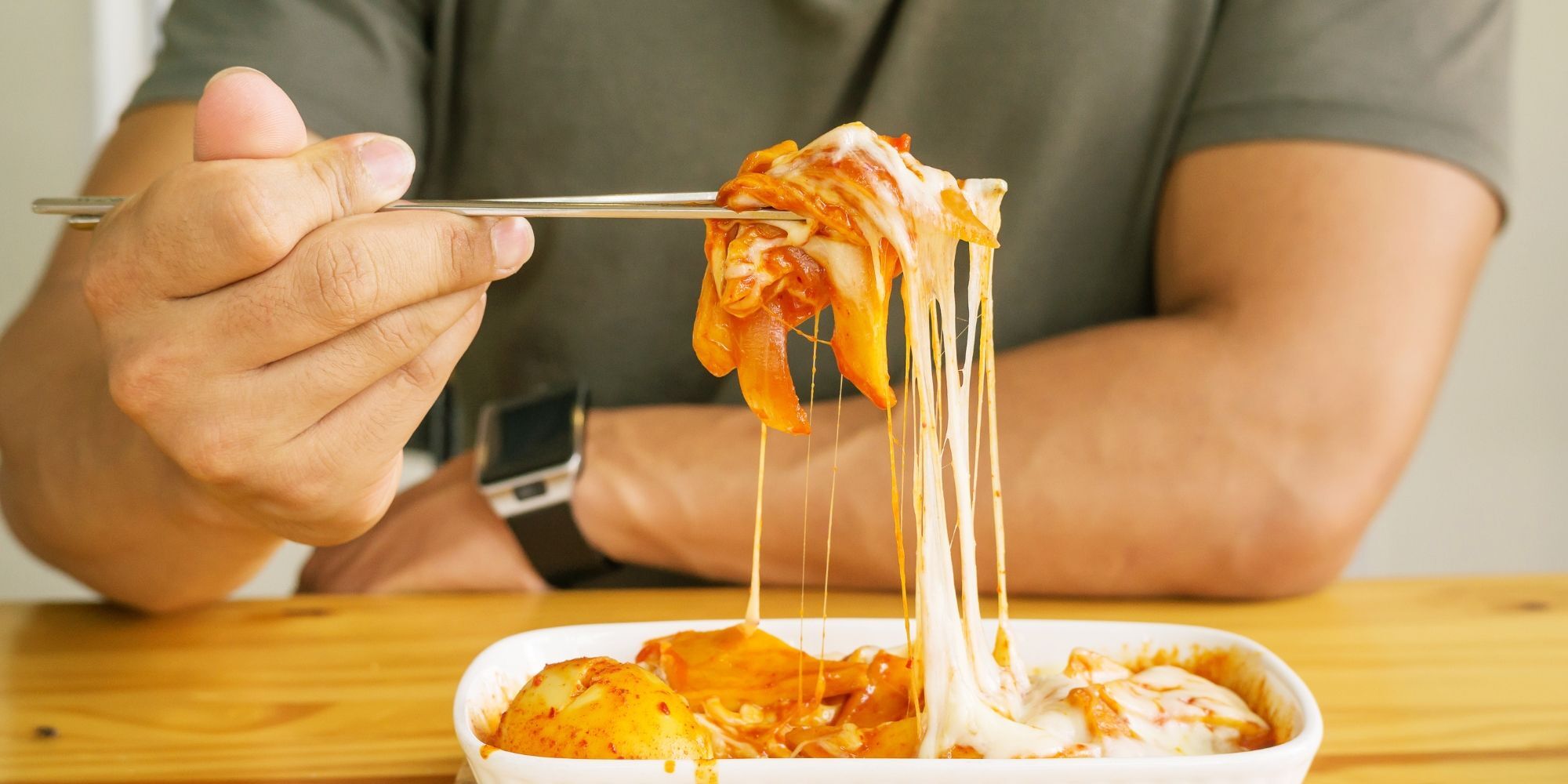 pria sedang menyantap makanan pedas dan berlemak