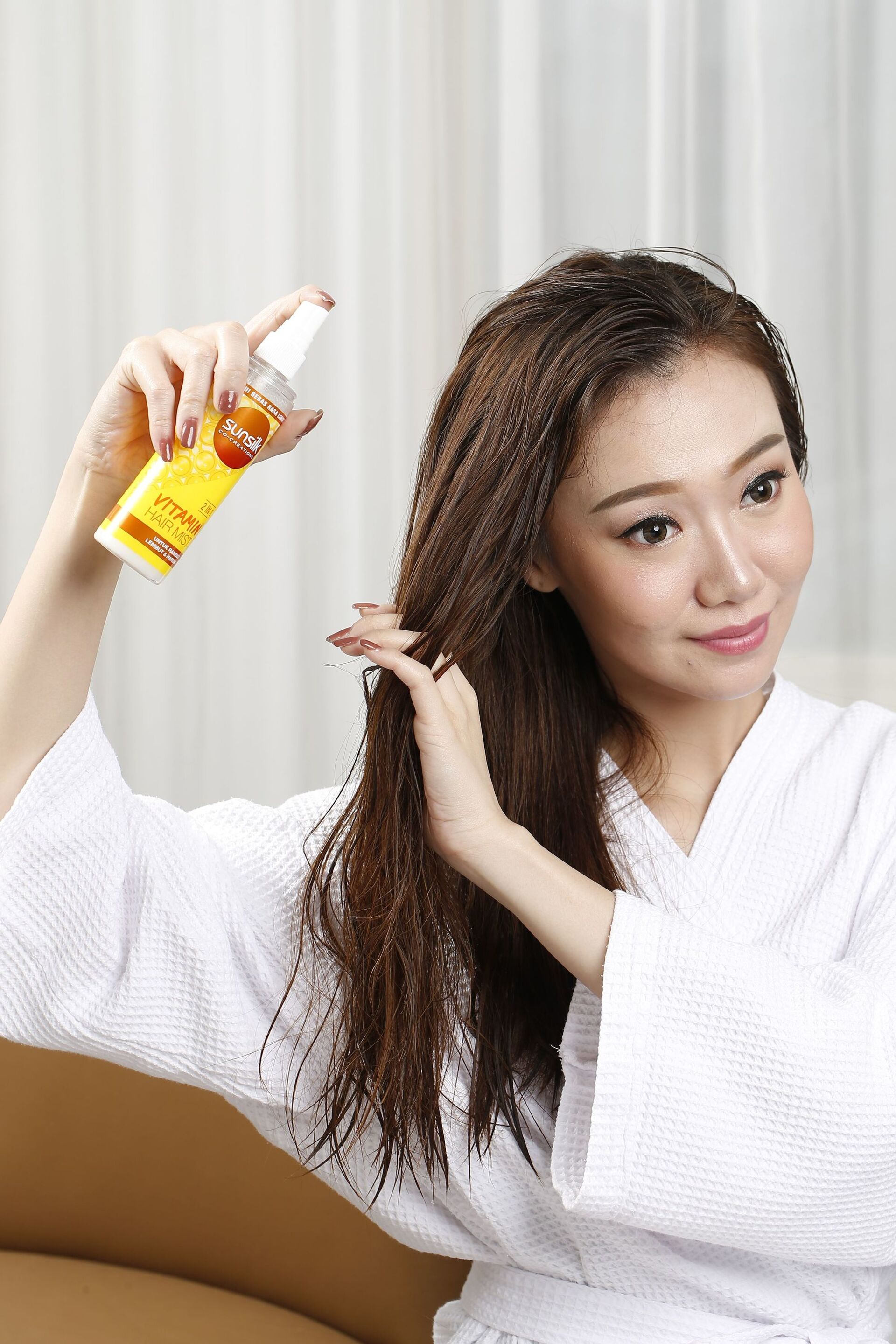 wanita asia sedang menggunakan hair mist dari sunsilk