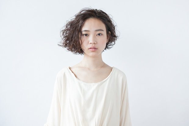 Bob asimetris untuk tampil modern sekaligus edgy sebagai gaya rambut keriting pendek. (Foto: All Things Beauty Thailand)