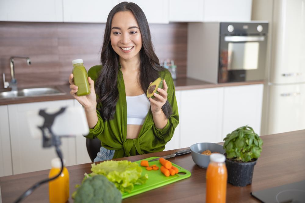 Wanita Asia berambut panjang memegang alpukat