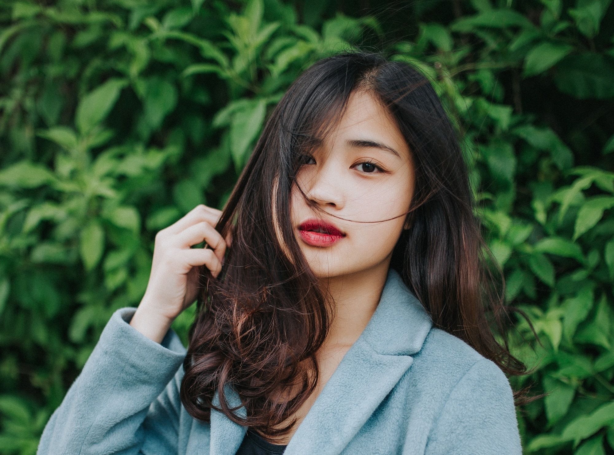 Wanita Asia dengan rambut panjang bergelombang dengan highlight
