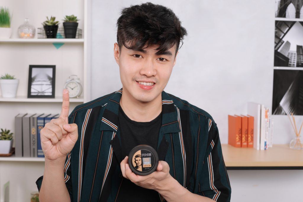 Pria asia menata rambut dengan pomade