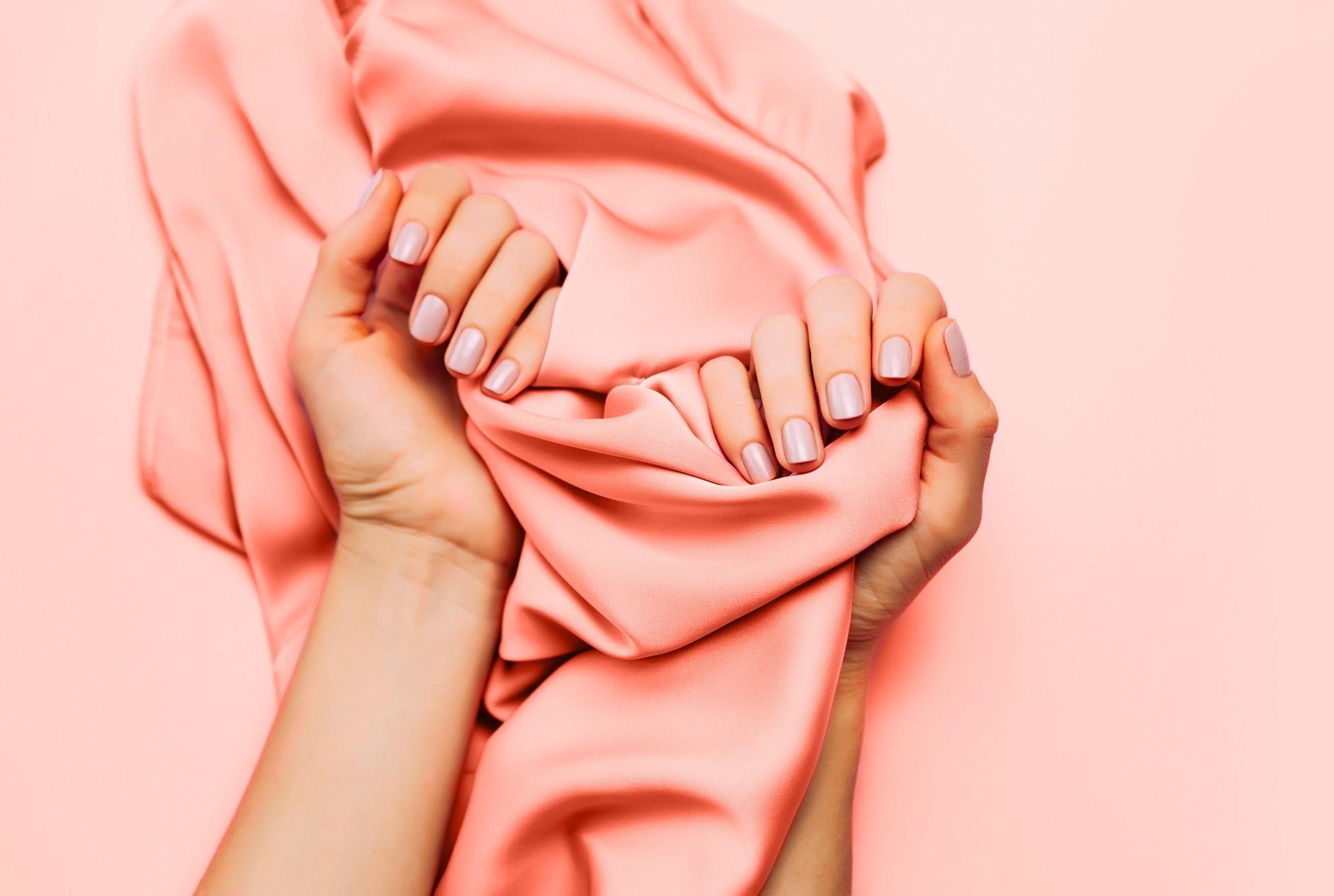 Wanita menggenggam scarf warna peach