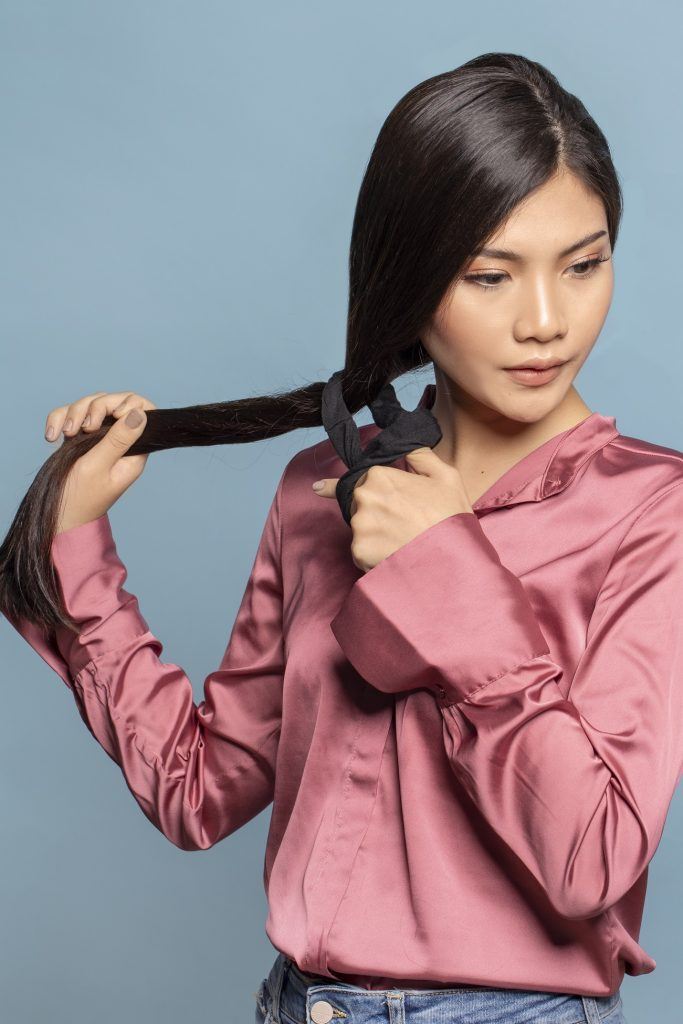 wanita asia mengikat rambut dengan scrunchie