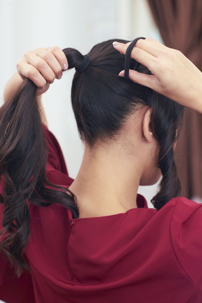 Pevita Pearce mengikat rambut dengan gaya high ponytail menggunakan baju merah