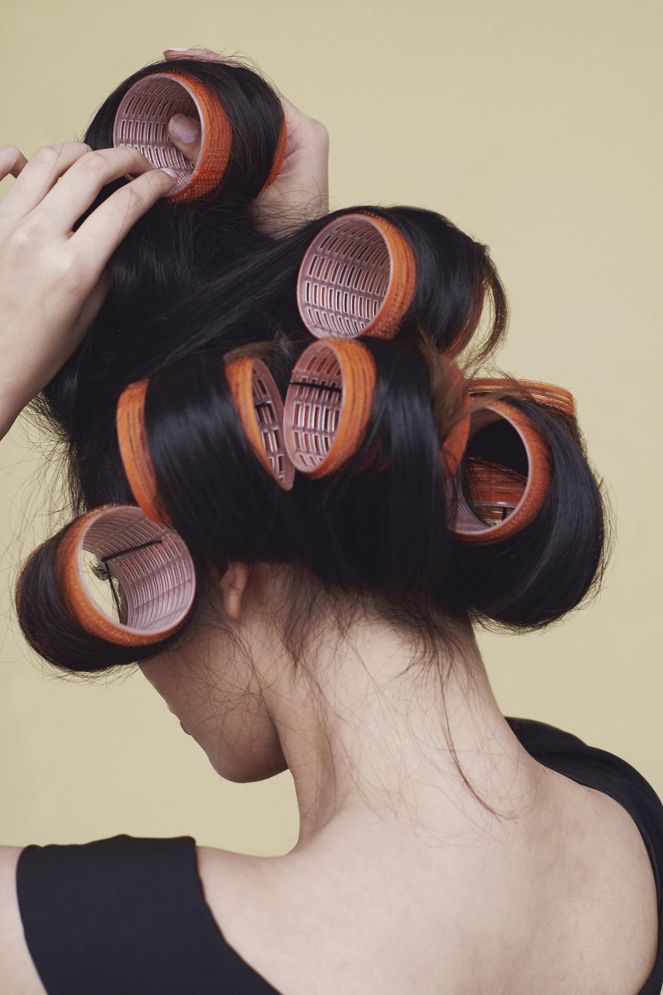 Wanita asia berambut hitam sedang menggulung rambut