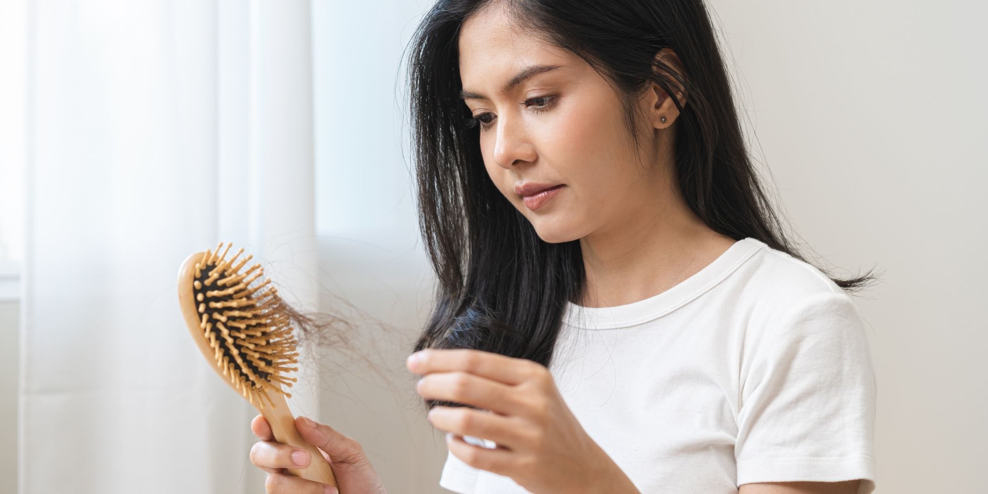 wanita yang khawatir dengan kerontokan rambut