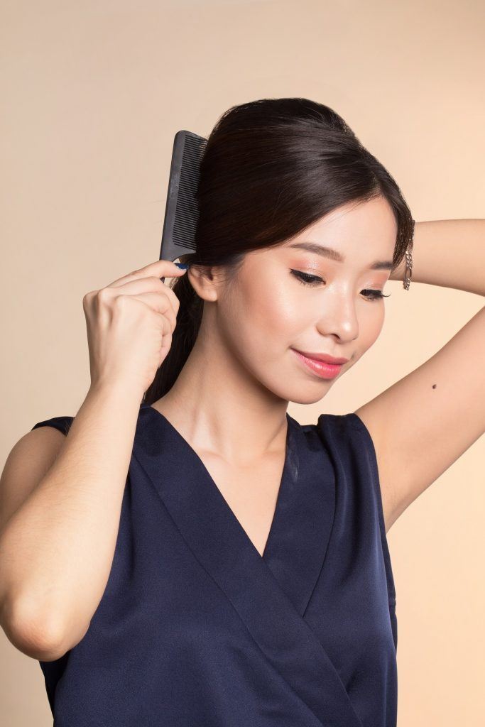 wanita asia berambut hitam sedang menyisir rambut untuk Vintage Ponytail Retro