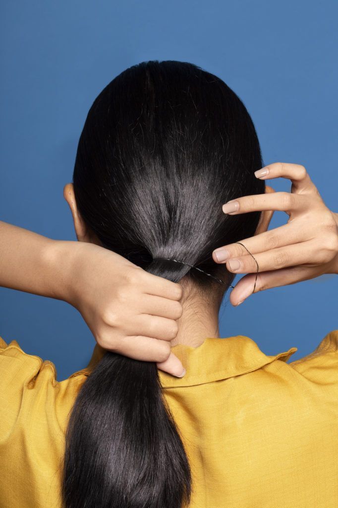 Wanita asia dengan rambut hitam menata rambut gaya ponytail