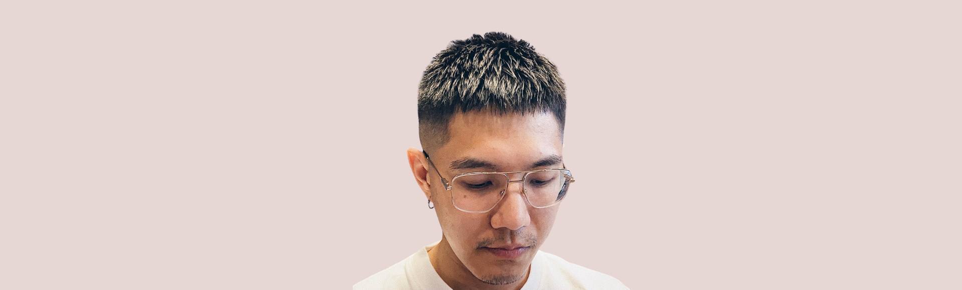 Pria Asia dengan gaya rambut crew cut yang meruncing atau spike pada bagian atas.