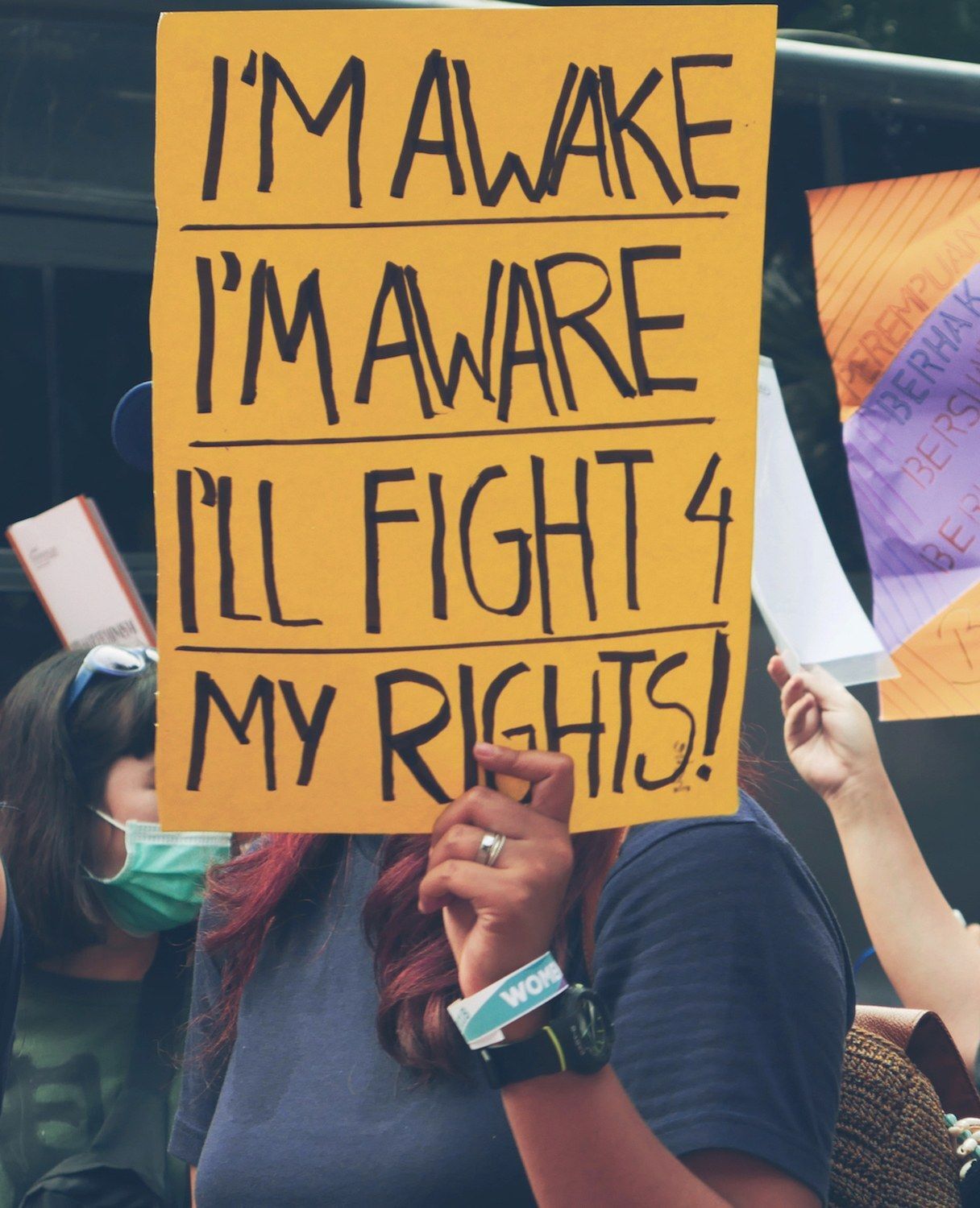 Papan demo dengan tulisan, pada kertas berwarna kuning