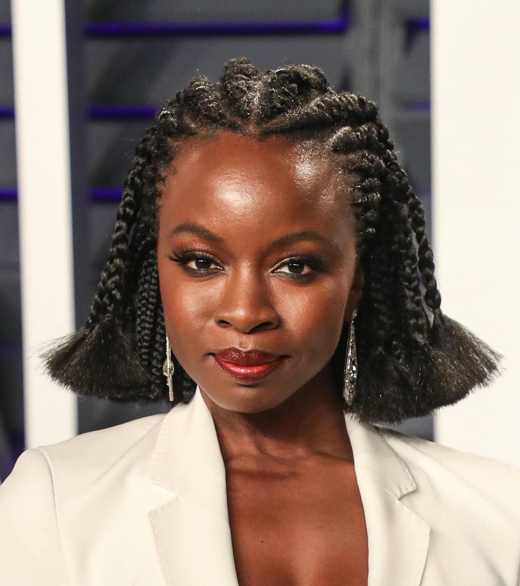 Danai Gurira dengan model rambut cornrow hitam pendek sebahu