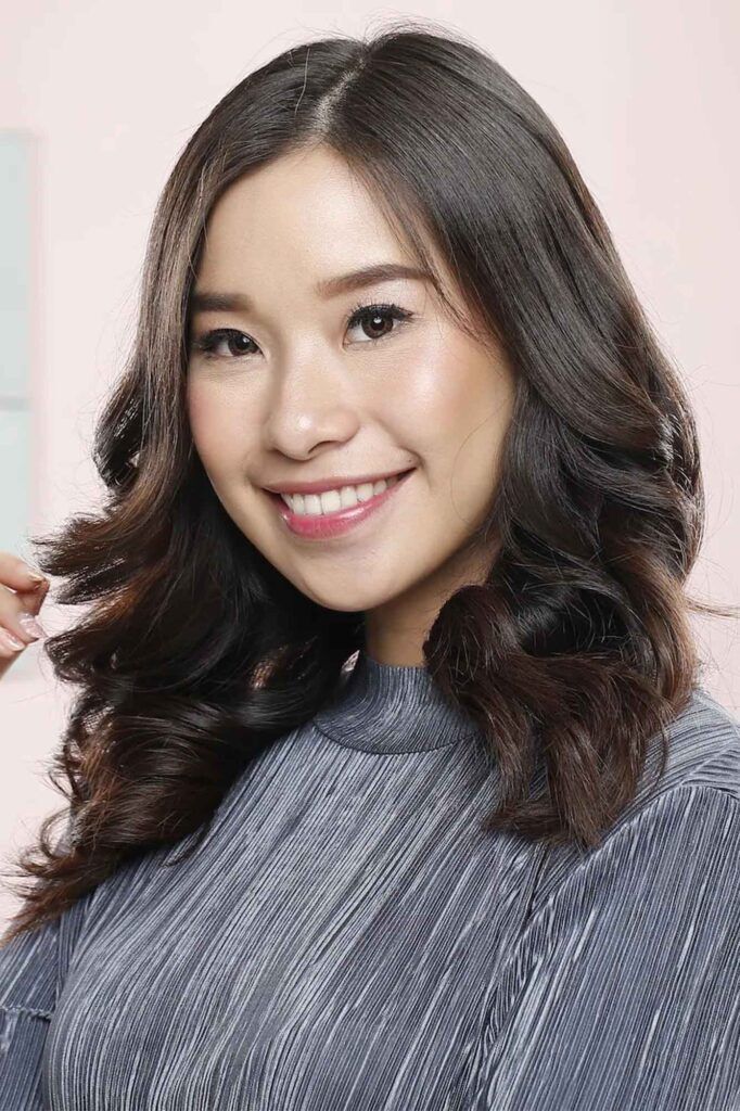 wanita asia dengan rambut dikeriting menggunakan catokan