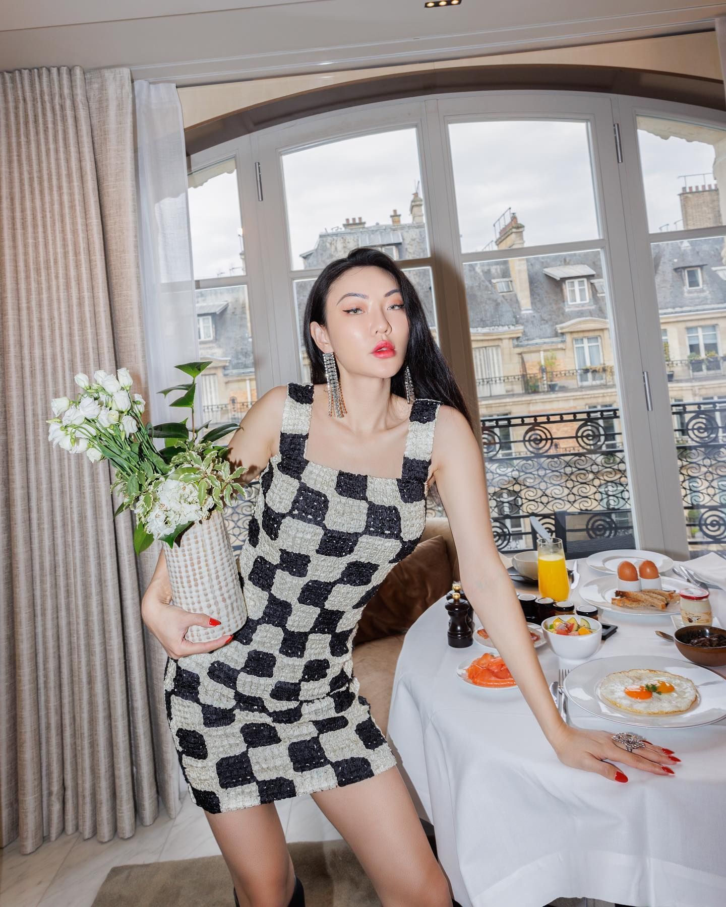 Wanita Asia berpose dengan vas bunga estetik