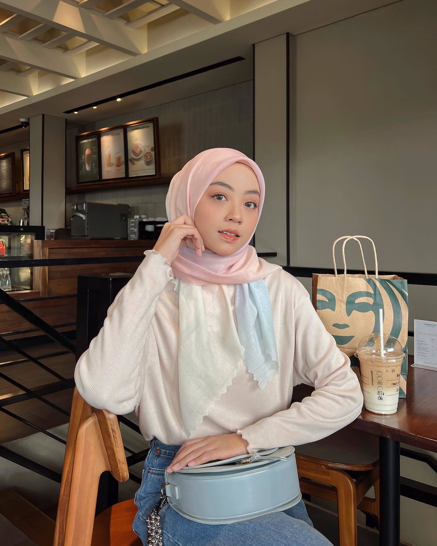Wanita Indonesia kenakan hijab segi empat warna pink gradasi.