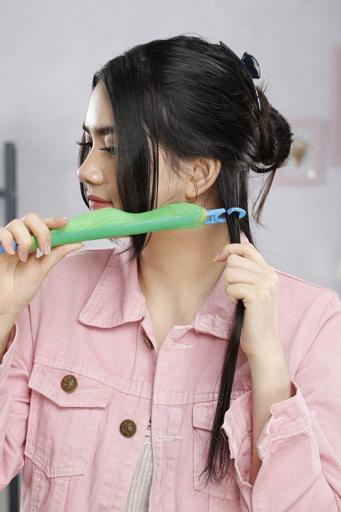 wanita asia dengan rambut panjang sedang membuat rambut keriting