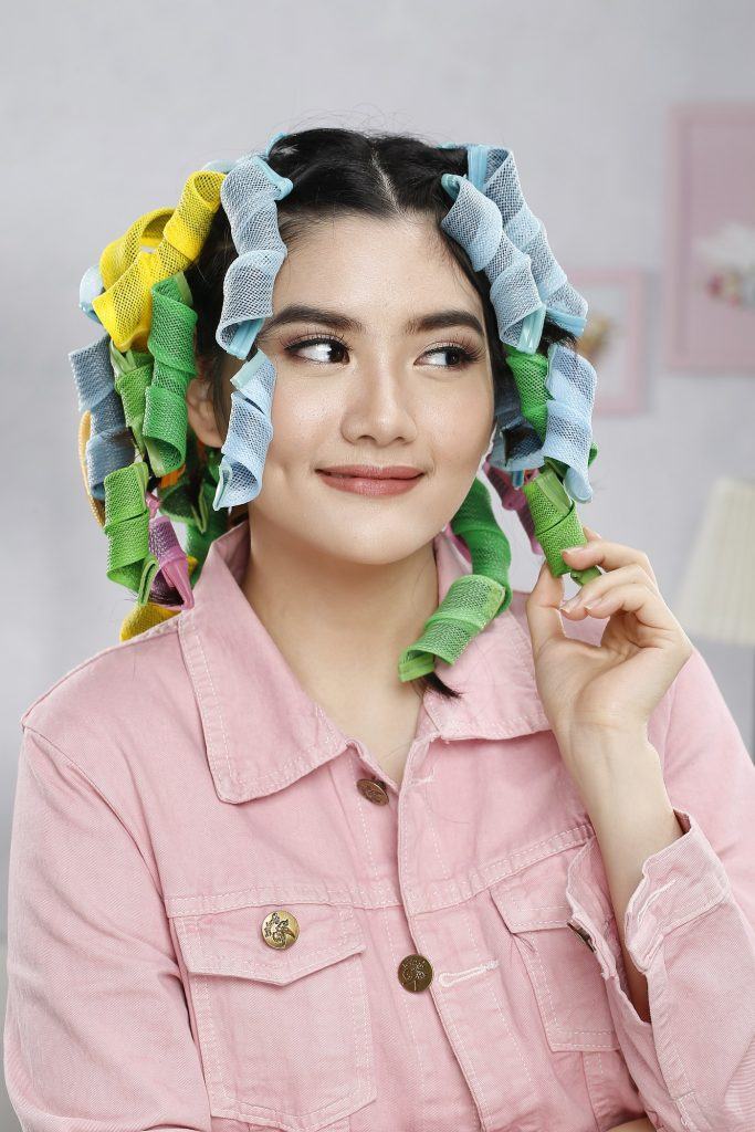 menggunakan alat pengeriting pada rambut