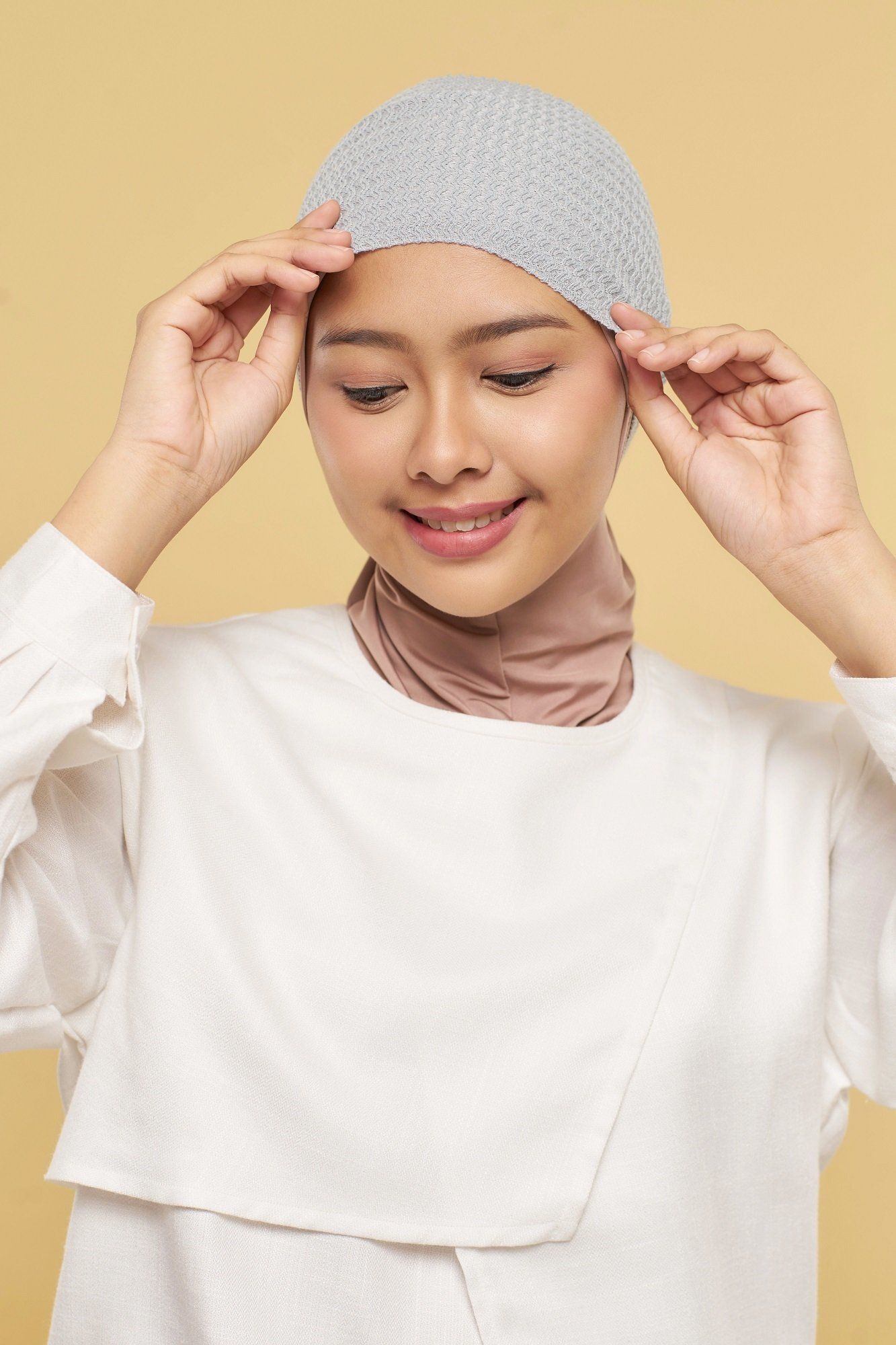 Wanita Asia memakai ciput rajut anti pusing