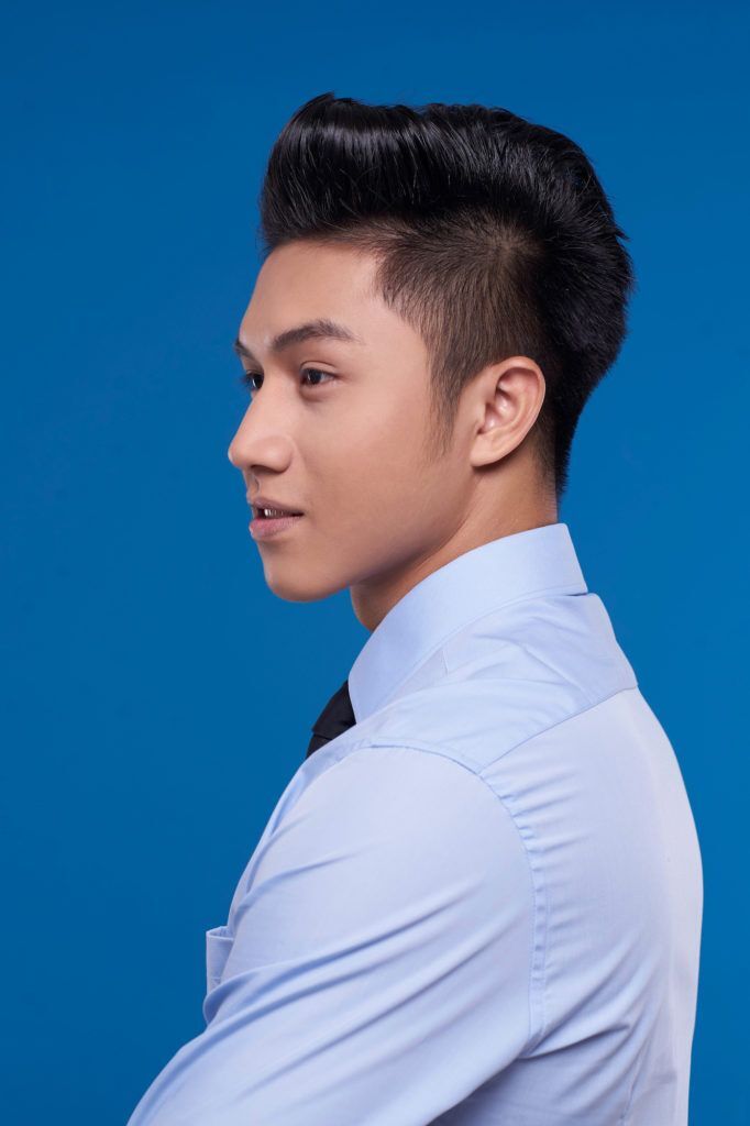 Pria asia dengan warna rambut hitam menggunakan gaya rambut pompadour.