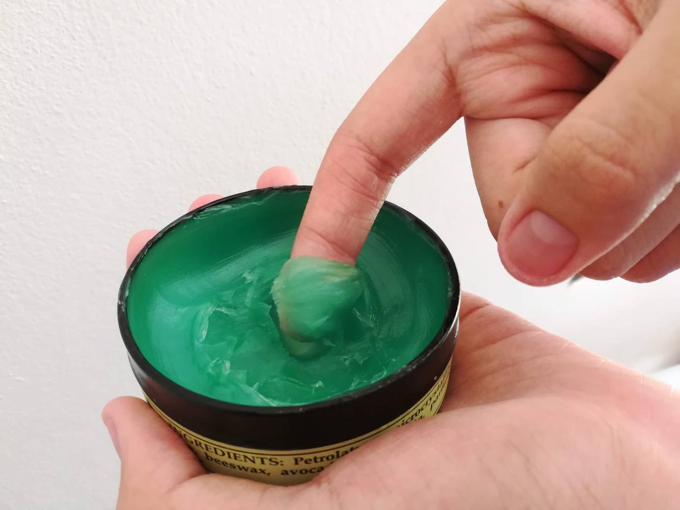 Pria yang sedang mencoba tekstur pomade yang creamy