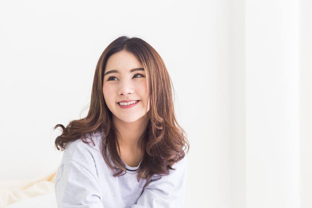 Model rambut wanita sesuai bentuk wajah bulat yang satu ini fokus pada area poni yang dicatok c-curl. (Foto: Shutterstock)