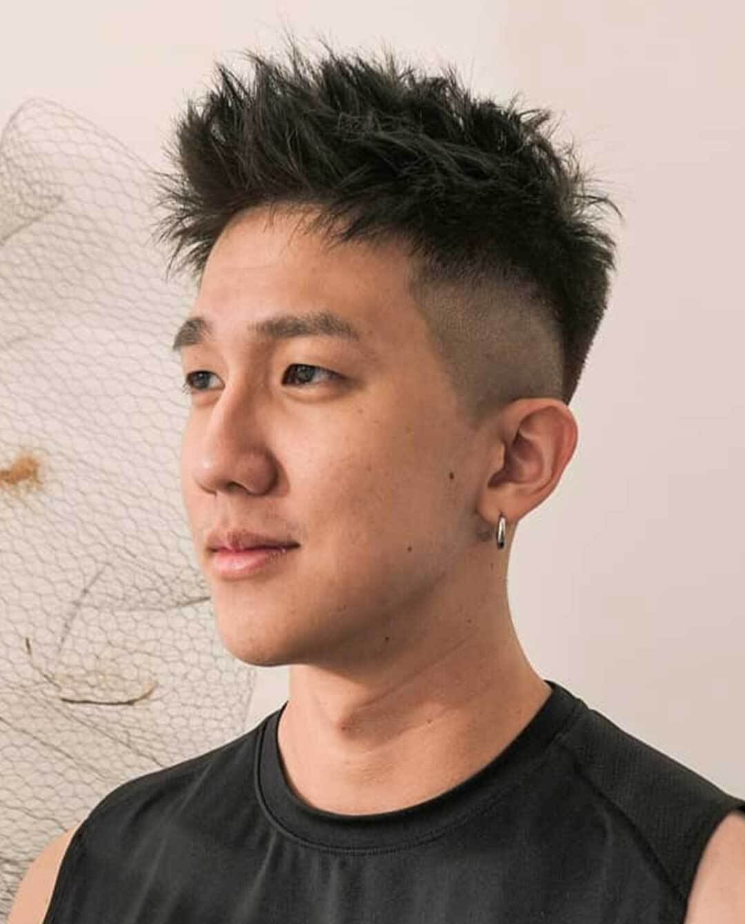 Pria Asia dengan gaya rambut undercut dengan sentuhan messy spiky.