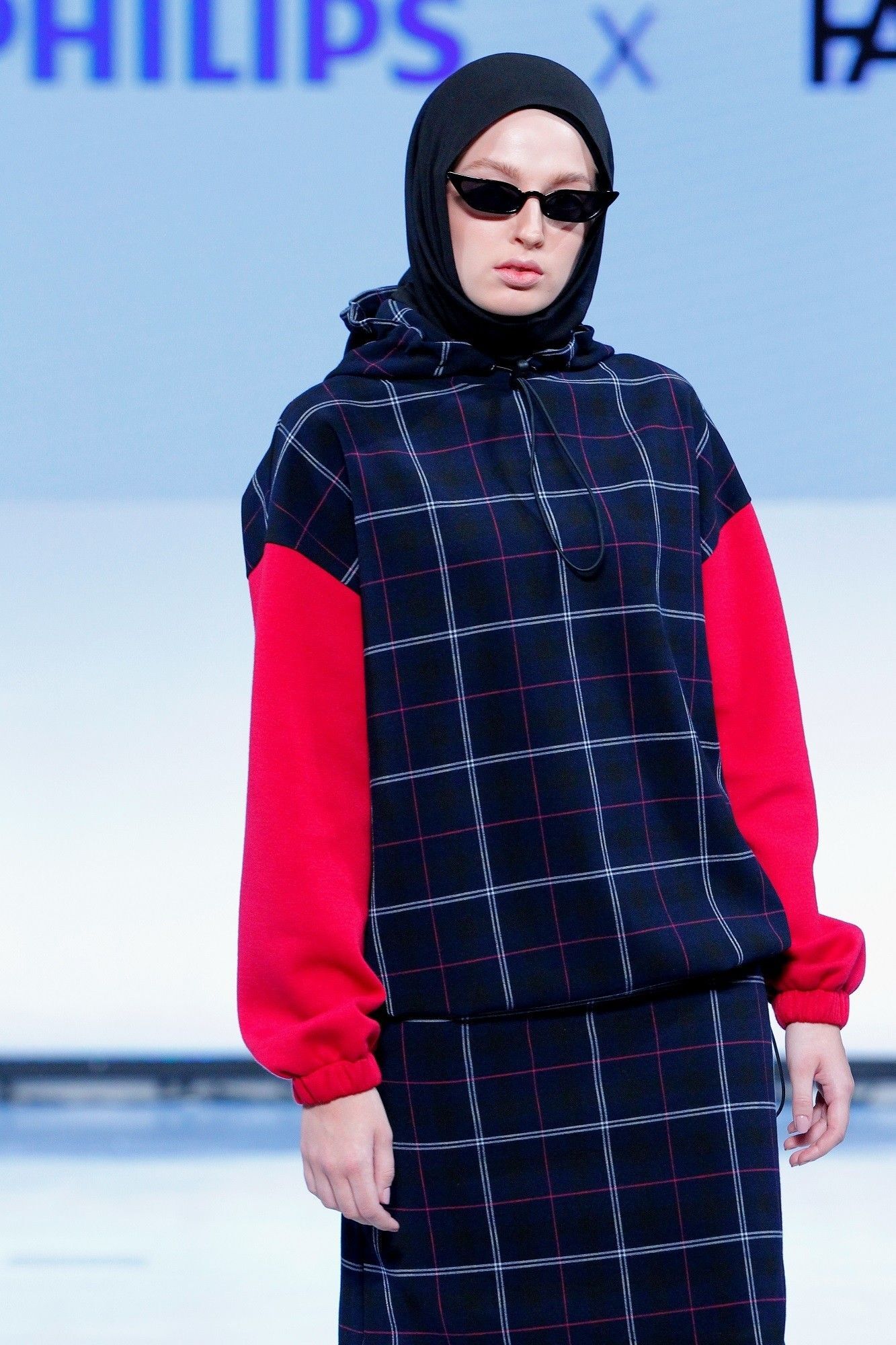 Wanita memakai kreasi hijab segi empat simple dan baju dari Rani Hatta