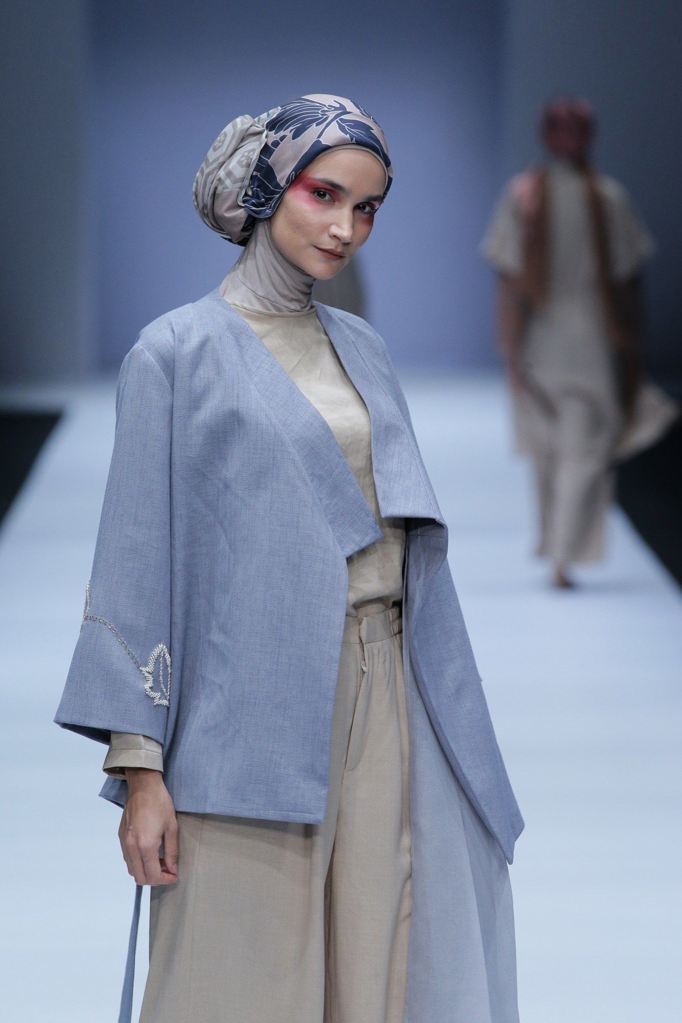 Model berhijab berjalan di catwalk JFW 2019 memakai baju KAMI IDEA