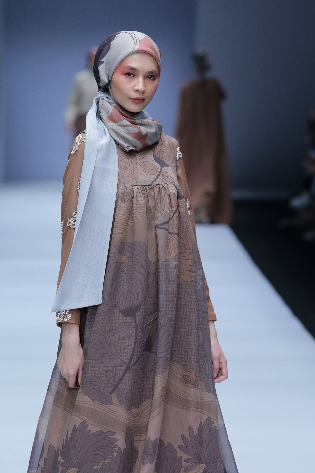 Model berhijab berjalan di catwalk JFW 2019 memakai busana rancangan KAMI IDEA