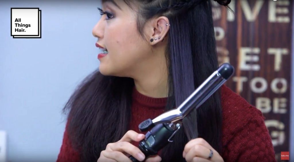 Indira Calista dengan rambut hitam menggunakan curling iron untuk mengeriting rambutnya