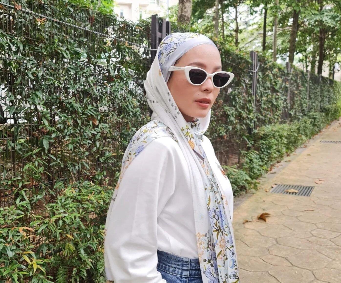 Selebgram Malaysia mengenakan hijab pashmina simple bermotif bunga.